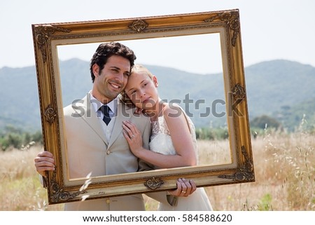 Newlyweds holding vintage picture frame