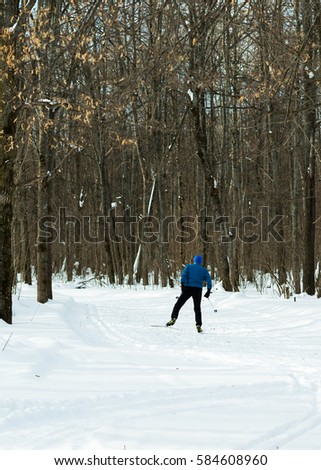 The man on the cross country skiing in winter forest. Ice ridge course skiing. Healthy lifestyle concept.