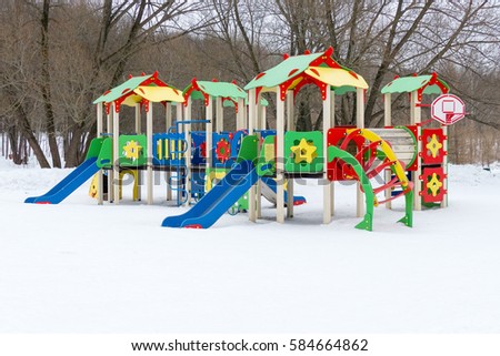 Colorful playground on yard in the winter park. Winter Landscape