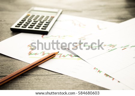 calculator and pencil on graffica the Dow Jones on forex market at grey table
