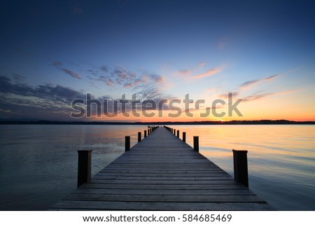 Lake at Sunset, Long Wooden Pier Royalty-Free Stock Photo #584685469