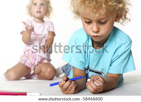 female and male blonde caucasian adorable kids play with color pens