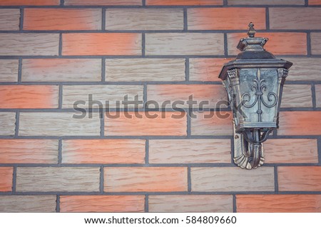 Red and grey brick wall with metal classic outdoor lantern for background.Copy space.