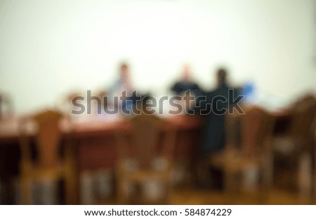 Business debate in office interior. Men in suits sitting near table. Blur abstract background of employees. business meeting room. Conference Discussion. People use new technology in team. Boardroom