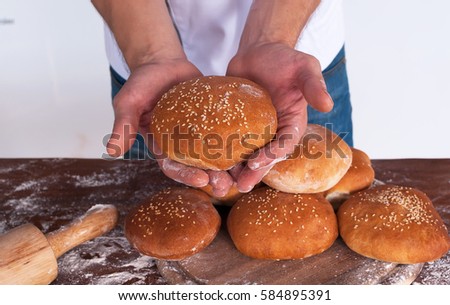 Baker man holding just cooked  bread