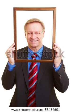 Smiling senior businessman looking through an empty picture frame