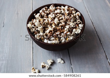 a bowl with chocolate popcorn on wood Royalty-Free Stock Photo #584908261
