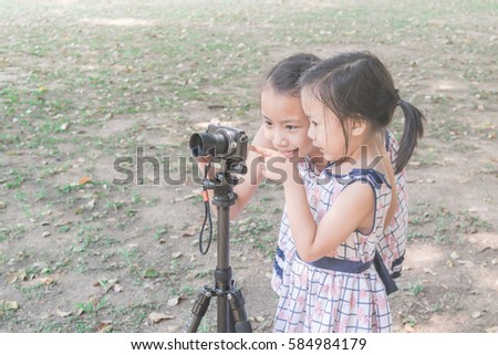 Beautiful together asian girl enjoy to take photographs in the garden.