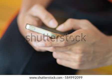 Man using gold smartphone on top of phone