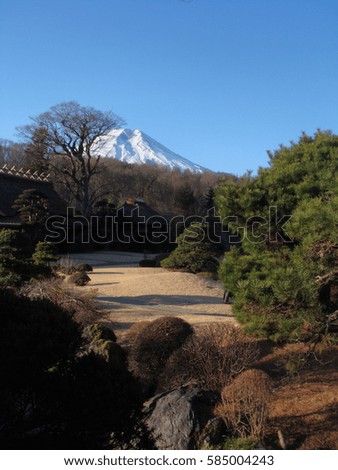 Mount Fuji covered with snow above traditional garden in Oshino Hakkai village in Japan in winter