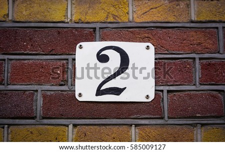 House number two (2) on a brick wall
