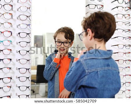  boy choosing glasses at optics store
