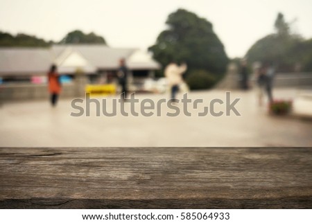 Empty wooden table in front of abstract blurred background of courtyards and people . can be used for display or montage your products.Mock up for display of product