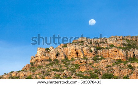 A near full moon rising above the mountains in the Western Cape, South Africa