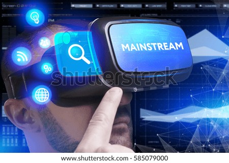 Business, Technology, Internet and network concept. Young businessman working in virtual reality glasses sees the inscription: Mainstream
