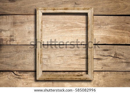 Old picture frame on wood wall.
