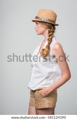 Side view of confident serious woman looking forward with hands in pockets