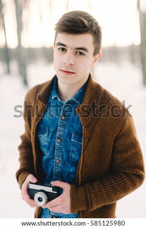stylish boy with a camera, portrait, winter background
