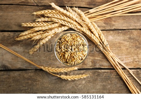 Malt in glass and spikes on wooden background Royalty-Free Stock Photo #585131164