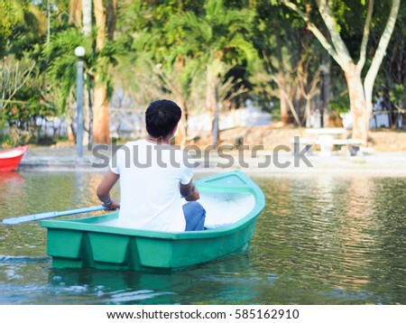 A man sailing boat in pond.