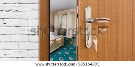 Half opened door to a bedroom, handle closeup. Welcome, privacy concept. Entrance to the hotel suit, modern interior design.