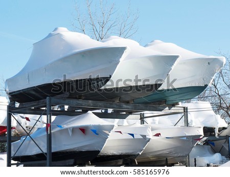 Boats stacked and stored on racks in the winter Royalty-Free Stock Photo #585165976