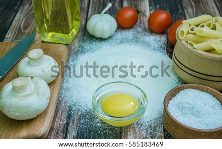 Still life with pasta ingredients and wooden accessories
