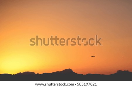 Airplane taking off at sunset