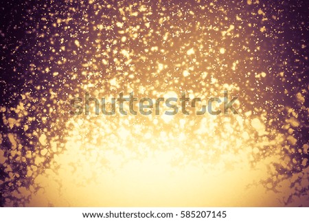Golden abstract sparkles or glitter lights. Festive gold background. Defocused circles bokeh or particles. Template for design