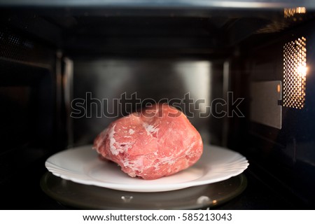 Frozen pork defrosted in the microwave Royalty-Free Stock Photo #585213043