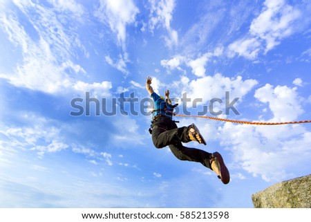 The first jump off the cliff with a safety rope. Royalty-Free Stock Photo #585213598