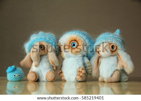 Photo of toy animals, owl, elephant, rabbit and a little bird. They are dressed in warm knit hats. Photo illustration for a suitable warm clothing advertising, woolen thread.