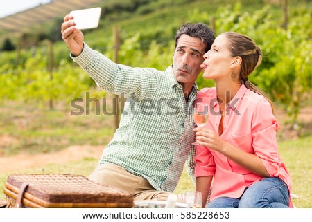 Happy couple taking a selfie in vineyard