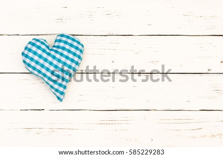 Blue heart on white wooden background with copy space.