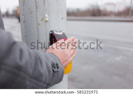 Man wait for crossing road with crossing button

