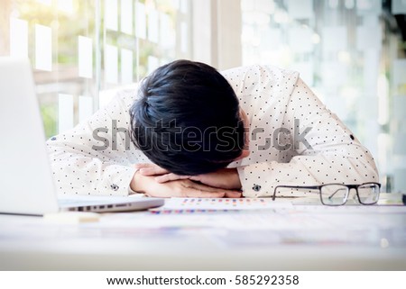tired businessman sleeping while calculating expenses at desk in office.