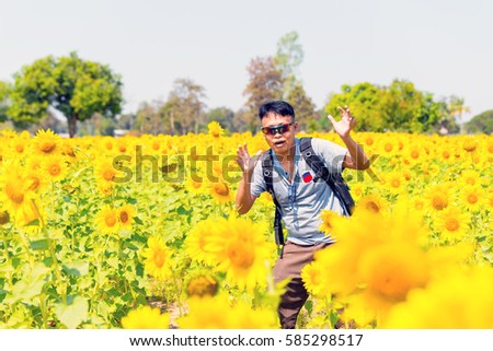 Asian tourists in a field of sunflowers.Asian man is travel in to Sunflower field.