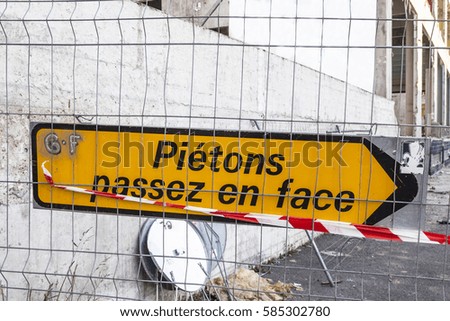 A road sign in French saying for pedestrians to use the other side.