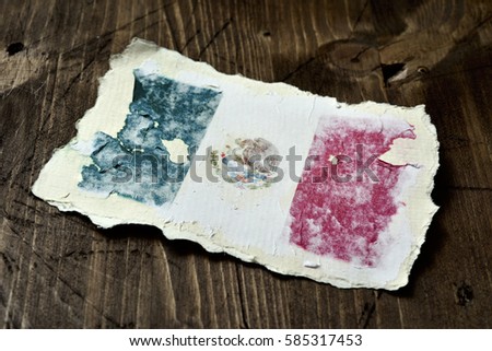 the flag of Mexico in an aged piece of paper on a rustic wooden background