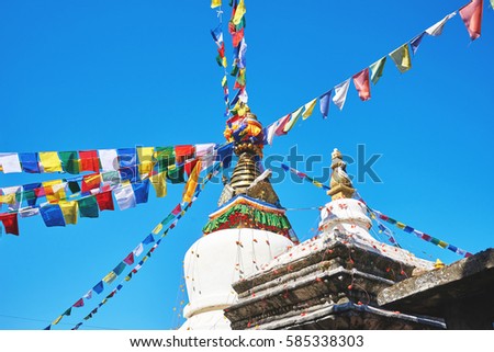 Main stupa with tibetan prayer flags in Thrangu Tashi Yangtse Monastery (Namo Buddha) in Nepal Royalty-Free Stock Photo #585338303