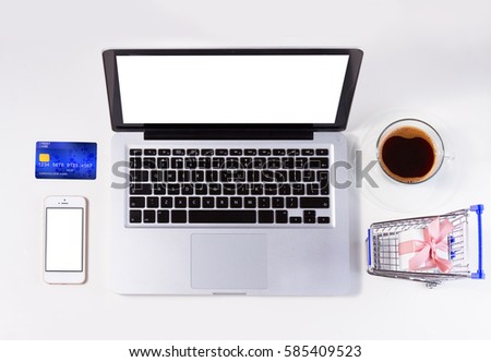 On-line shopping concept - lapytop, shopping cart, credit card and coffee