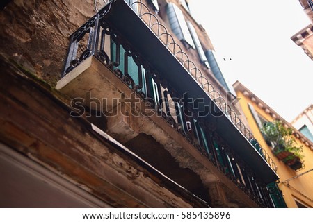 A closeup picture of an old decorated stone and steel balcony