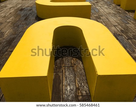 Yellow wooden box resting on the wooden floor.