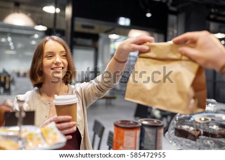 small business, takeaway food, people and service concept - happy female customer with coffee cup taking paper bag from man or barman at vegan cafe Royalty-Free Stock Photo #585472955