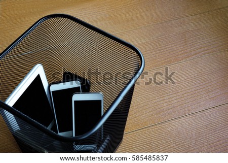 Smartphones in trash bin with copy space