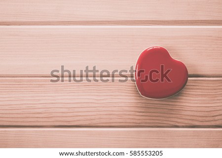 Red heart on wood background with copy space. vintage retro color style
