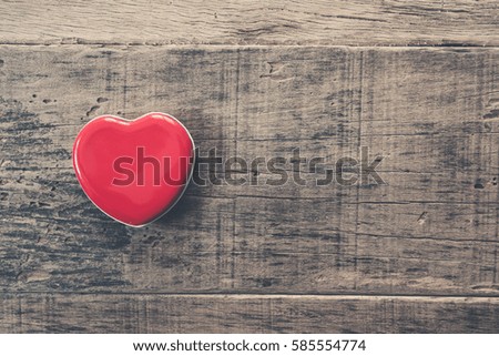 Red heart on wood background with copy space. vintage retro color style