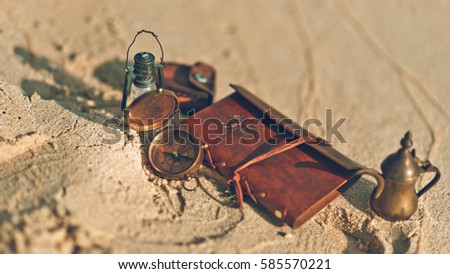 Antique compass, oil lamp and retro collections on beach in vintage style image. 
