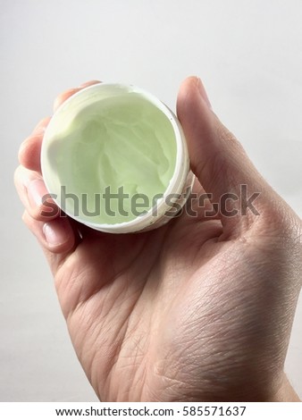a hand holding lotion pot Royalty-Free Stock Photo #585571637
