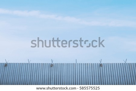 Sheet metal fence for roof, wall, warehouse, factory building on blue sky background.
